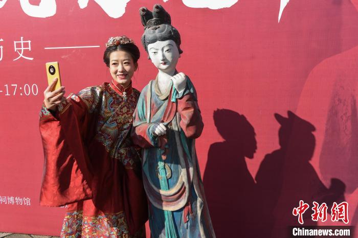 汉服爱好者在与侍女像雕塑(模型)合影。　武俊杰 摄