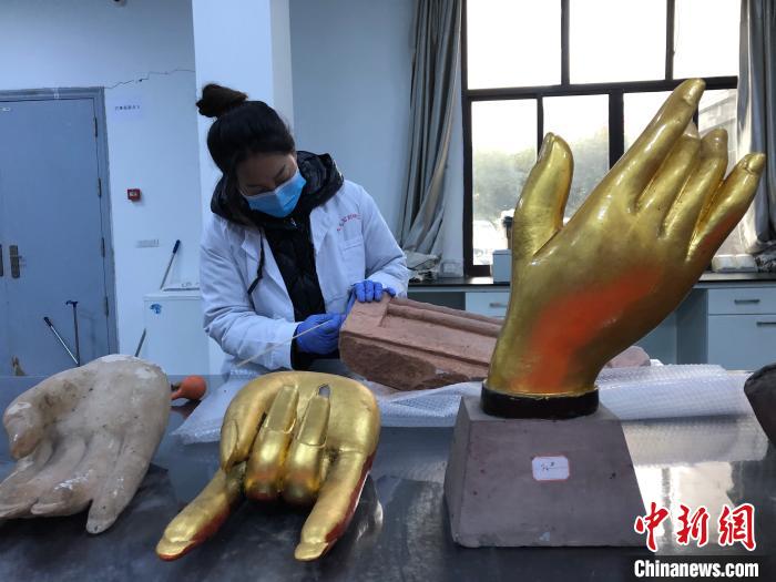 图为大足石刻研究院工作人员开展维护工作。　钟旖 摄