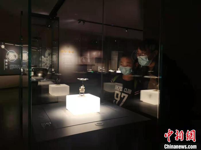 10岁男孩陈泽楷自制了一盏“走马灯”，与母亲前往参观古灯。他们在“立鸟形灯”前久久驻足。　高雨晴 摄