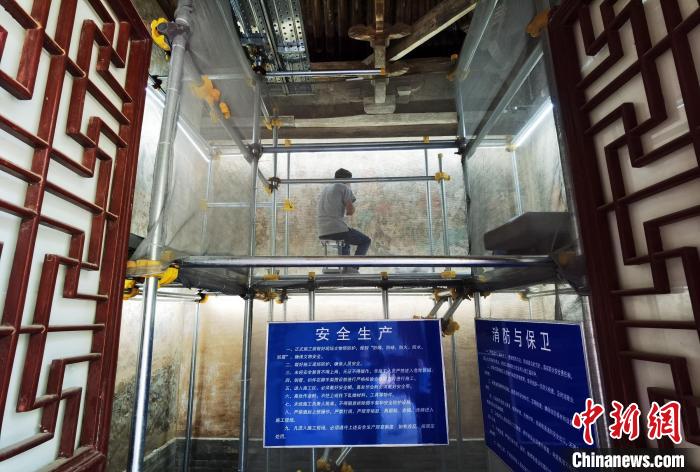 敦煌研究院文物保护技术服务中心的工作人员正在修复壁画。　胡健 摄