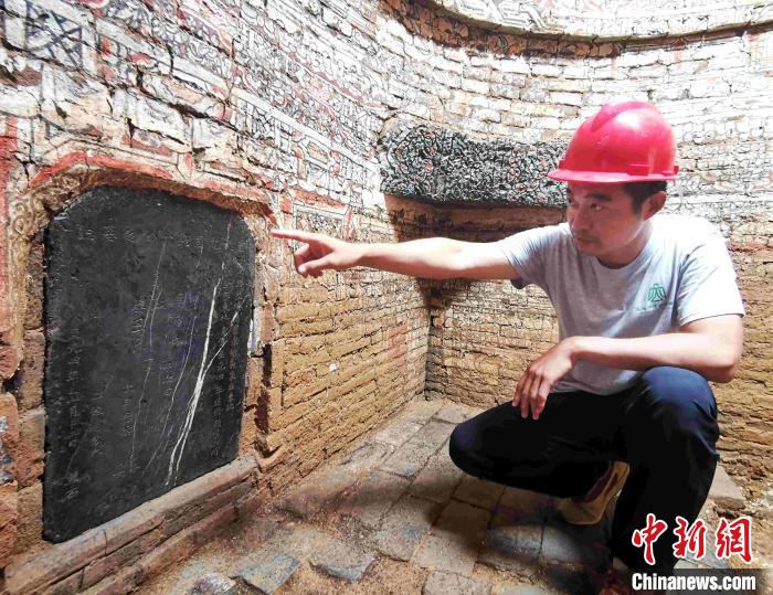考古现场领队介绍墓志上的文字。 赵晓 摄 考古现场领队介绍墓志上的文字。 赵晓 摄