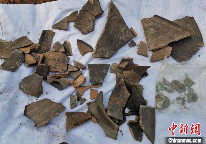 现场出土的陶片、铜钱等。 赵晓 摄 现场出土的陶片、铜钱等。 赵晓 摄